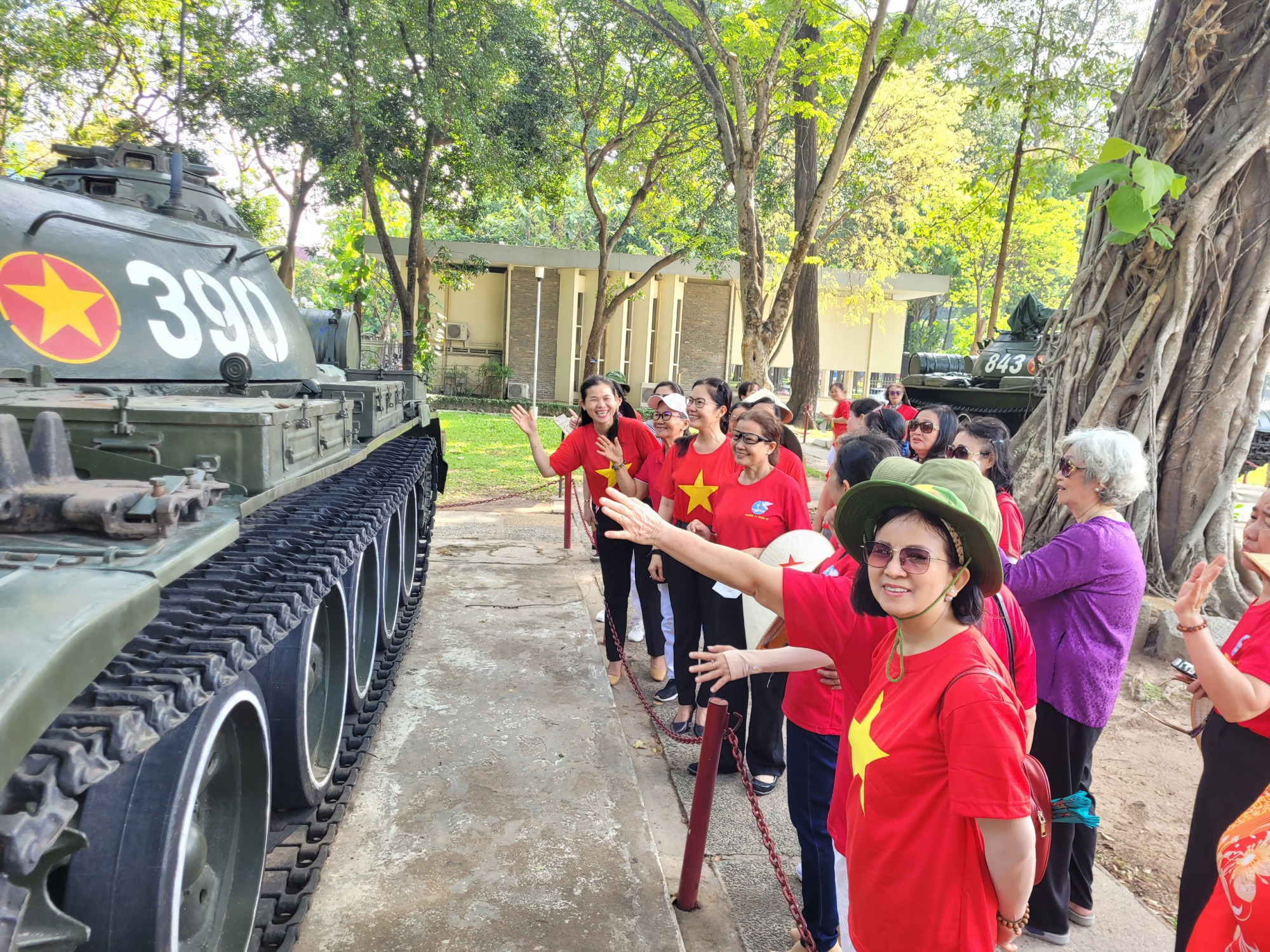 Bà Hà Thị Xuân Hy (áo tím) cùng các hội viên, phụ nữ phường 14, quận 10 bên chiếc xe tăng 390 - chiếc xe húc đổ cổng chính dinh Độc Lập trong ngày 30/4/1975