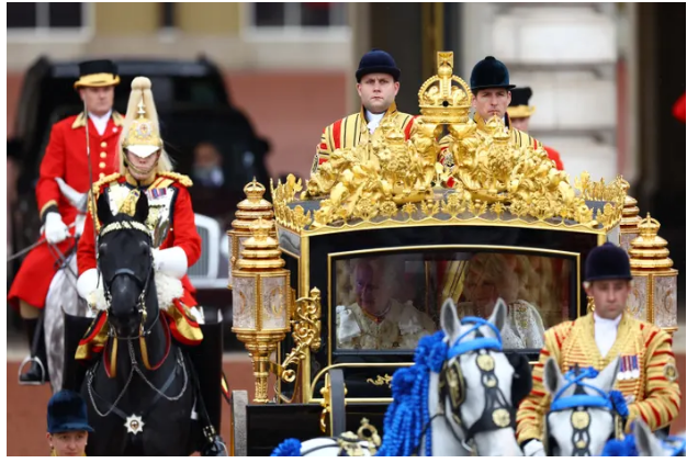Khi đoàn diễu hành đi chậm dọc theo Trung tâm mua sắm, đám đông vẫy tay và cổ vũ. Vua Charles của Anh đi trên chiếc Diamond Jubilee State Coach từ Cung điện Buckingham.