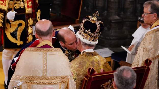 Các Tổng giám mục quỳ gối trước ngai vàng trước khi cam kết tin tưởng vào Vua Charles III. Hoàng tử William cũng quỳ gối và hôn sau tai cha để cam kết trung thành với cha mình. 