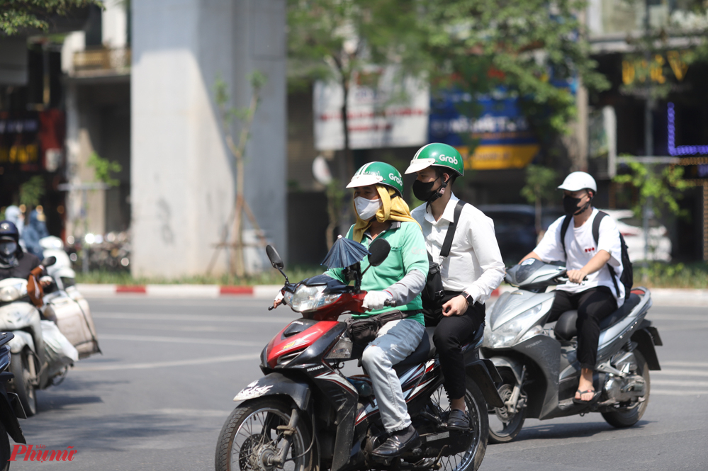 Hơi nóng từ trên đầu, từ mặt đường phả lên khiến người đi đường thấy ngột ngạt.