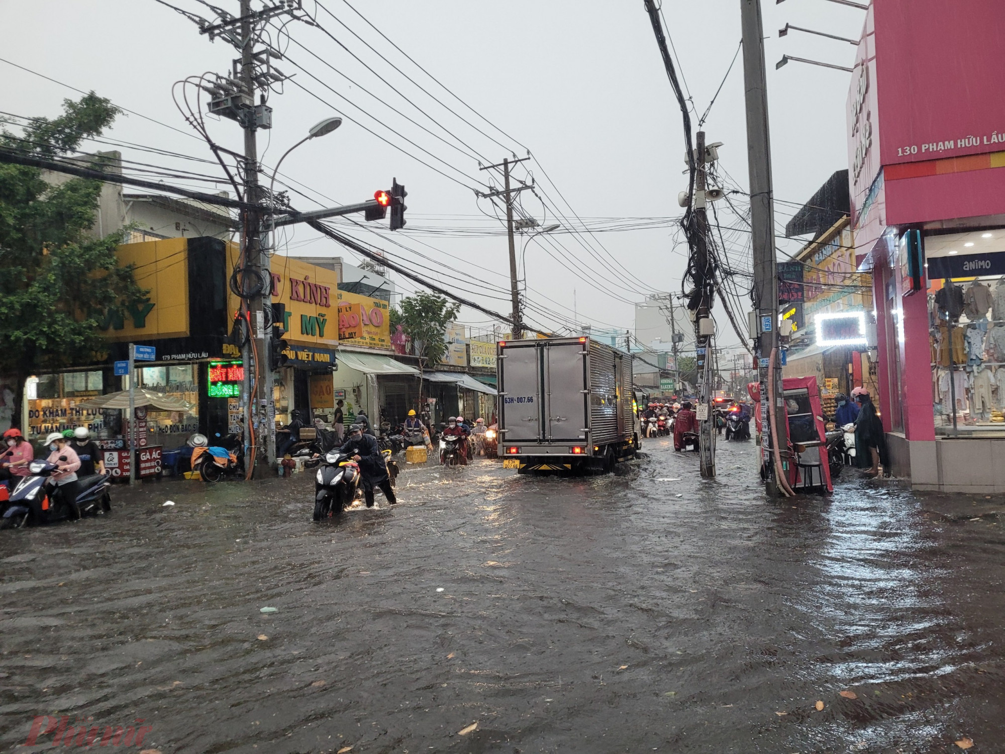Cơn mưa lớn khiến nhiều tuyến đường ở quận 7 ngập nước. Trong ảnh: Đường Nguyễn Lương Bằng lênh láng nước, nhiều phương tiện chết máy. Ảnh: Thu Lê