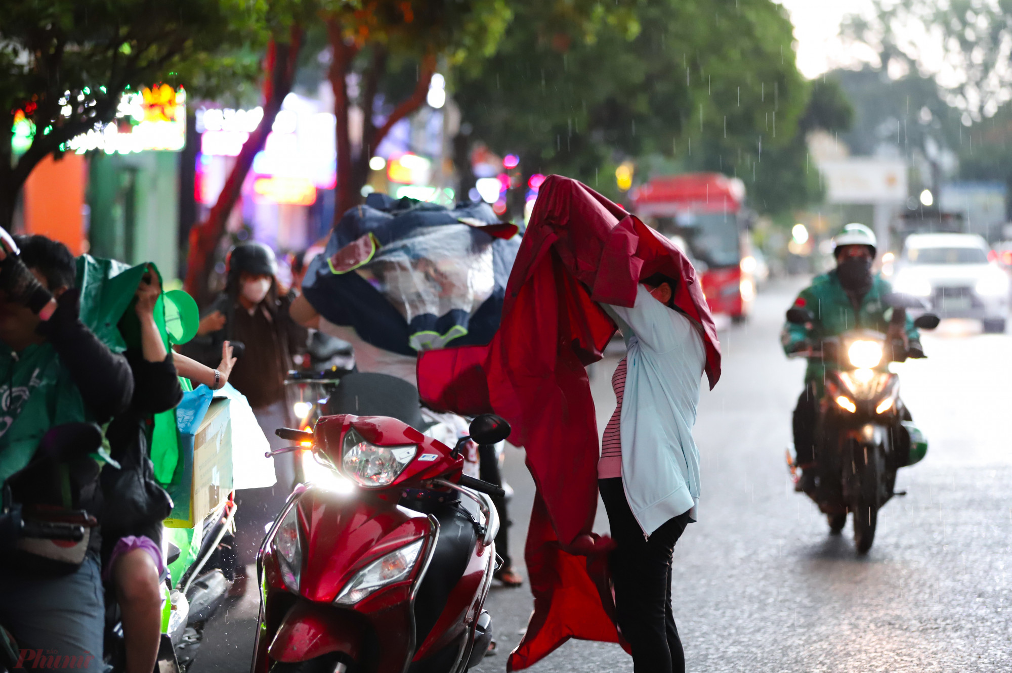 Nhiều người dân phải dừng xe ven đường để mang áo mưa di chuyển về nhà.