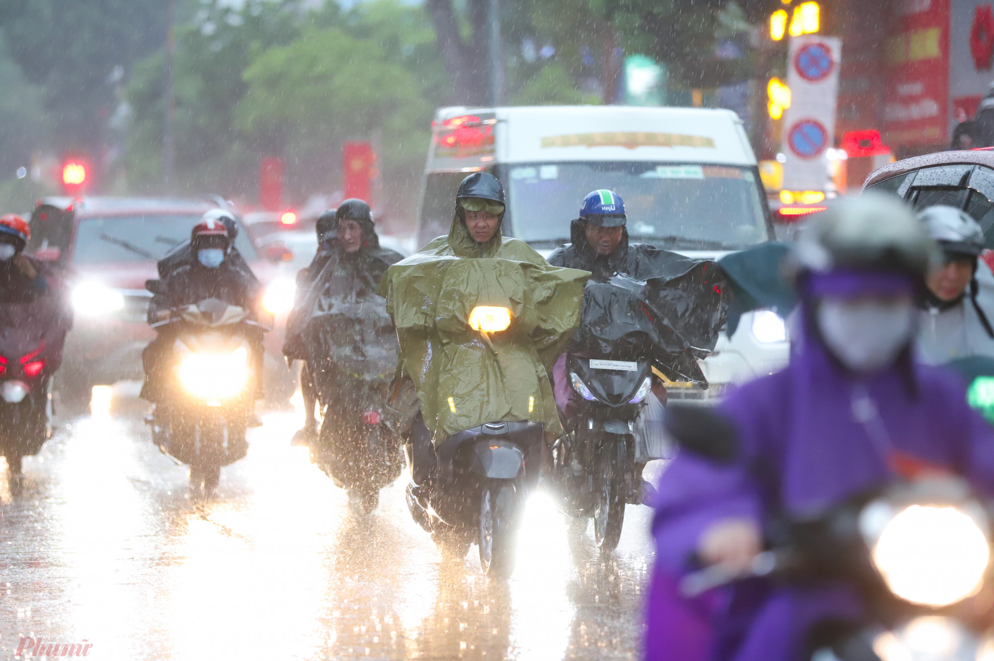 Dòng người đi chuyển trong cơn mưa lớn tại TPHCM. Dù khá khó khăn về tầm nhìn khi di chuyển, nhưng nhiều người tỏ ra thích thú khi xuất hiện cơn mưa hạ nhiệt độ xuống thấp.
