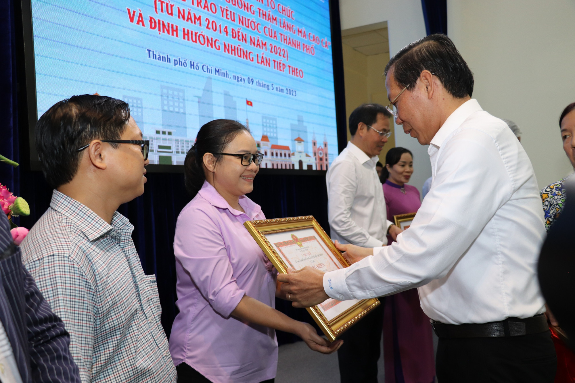 Chủ tịch UBND TPHCM Phan Văn Mãi trao bằng khen cho các cá nhân được tuyên dương “Những tấm gương thầm lặng mà cao cả”. Ảnh: Quốc Ngọc