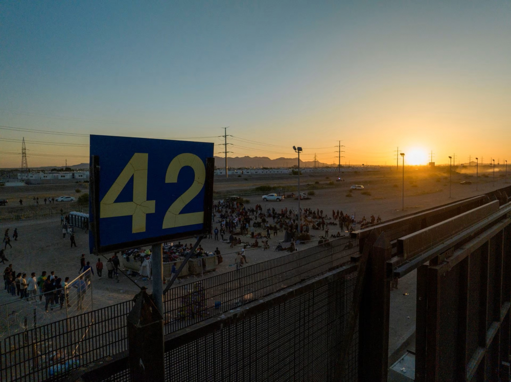 Người di cư đứng gần Cửa khẩu 42 dọc theo đường cao tốc biên giới ở El Paso, Texas, Mỹ hôm 11/5. (Ảnh: REUTERS)