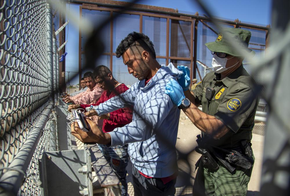Những người di cư được nhân viên Biên phòng kiểm tra khi họ vào El Paso, Texas từ Ciudad Juarez, Mexico. (Ảnh: AP)