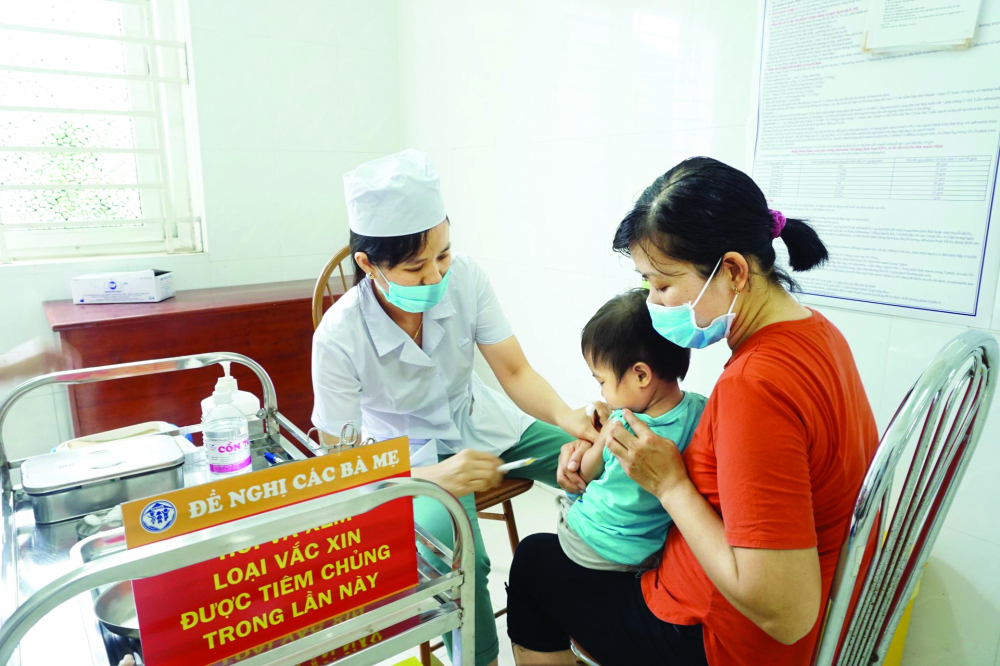 Tiêm vắc xin cho trẻ em ở Trạm Y tế xã Cự Khê, huyện Thanh Oai, TP Hà Nội. Từ khi có dịch COVID-19, tỉ lệ tiêm chủng các loại vắc xin cho trẻ đều giảm sút ẢNH: HUYỀN ANH