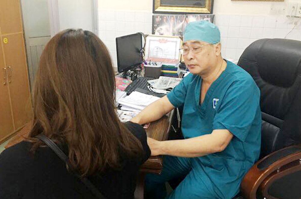 Bác sĩ Nguyễn Văn Tiến - Trưởng khoa Ngoại phụ khoa Bệnh viện Ung Bướu TPHCM -  đang tư vấn tầm soát ung thư cho người bệnh - ẢNH: PHẠM AN