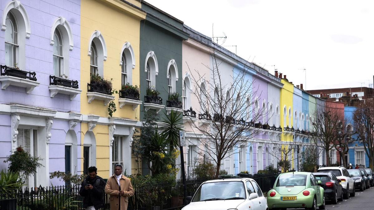 Một số người đi dạo qua những căn nhà đầy màu sâc ở London.