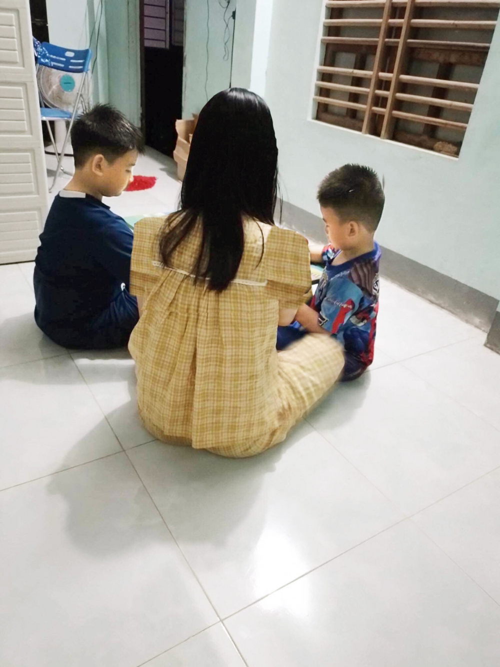 Chị Lưu Thị H. với hạnh phúc mỗi tối được vui đùa và dạy 2 con học - ẢNH: NHÂN VẬT CUNG CẤP