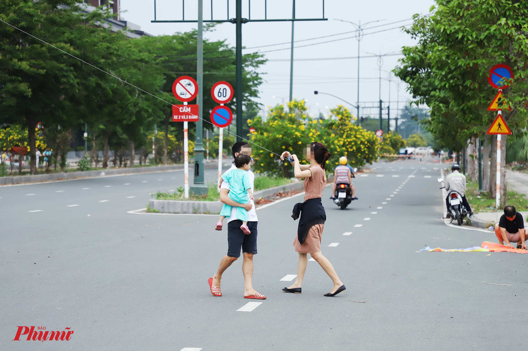 Một số người để lấy đà cho diều bay cao đã chạy từ bên này sang bên kia đường, trong khi xe cộ