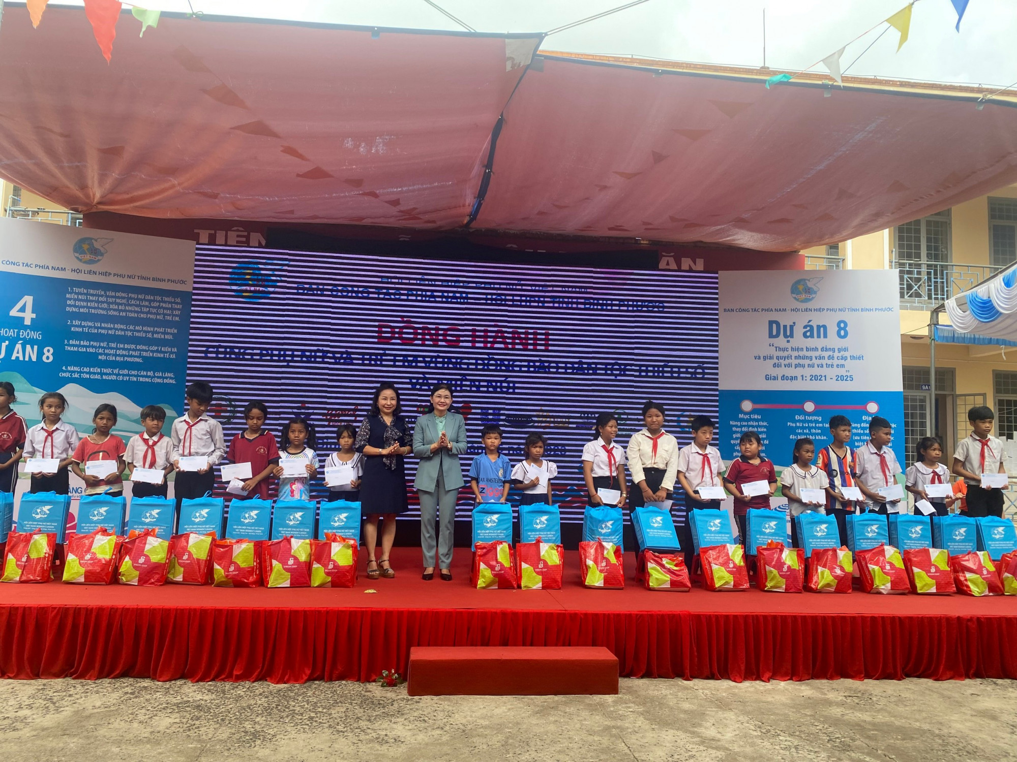 Bà Tôn Ngọc Hạnh - Phó chủ tịch Hội LHPN Việt Nam (áo xanh) trao quà cho học sinh có hoàn cảnh khó khăn