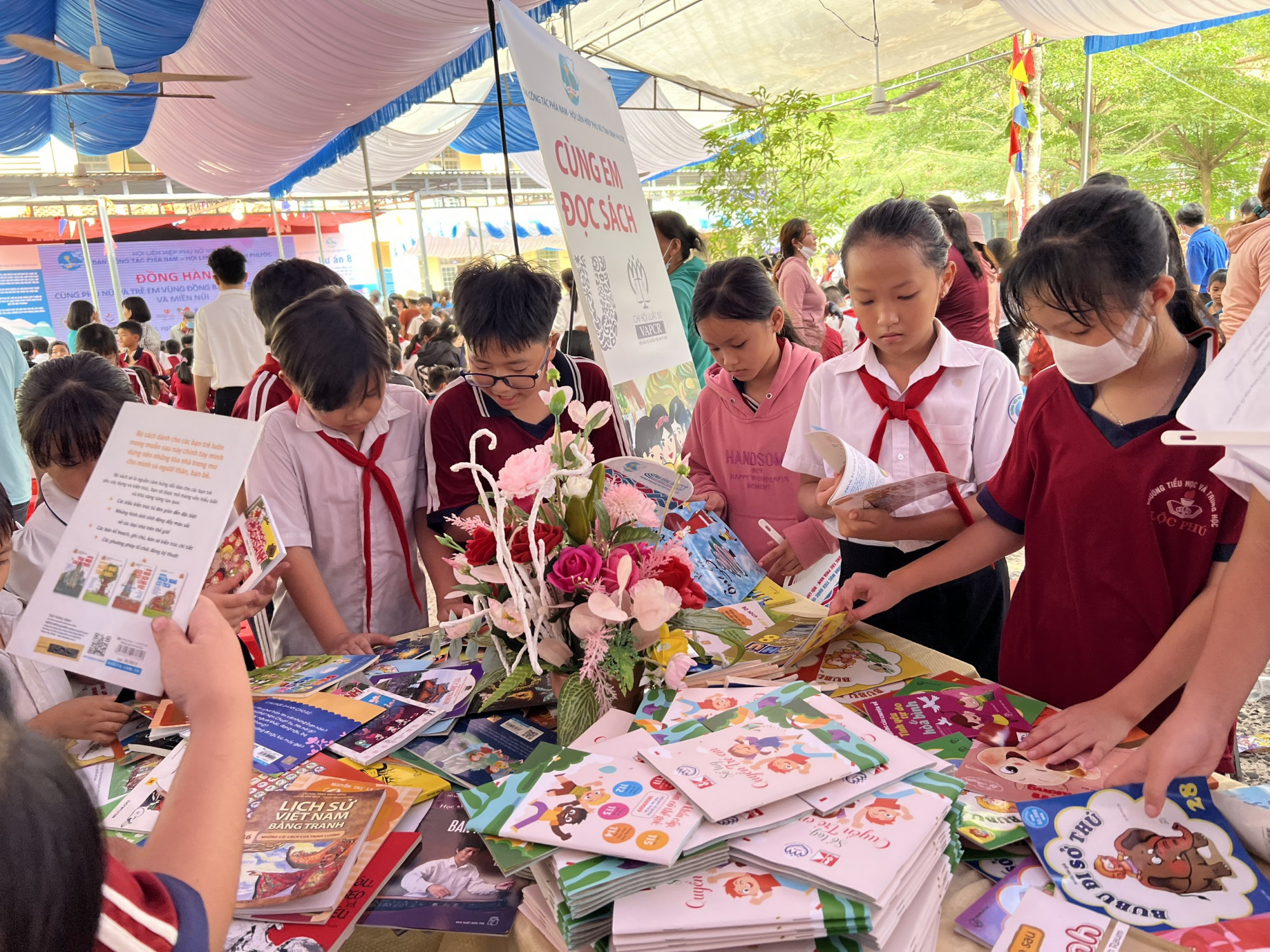 Học sinh trường tiẻu học và THCS Phú Lộc quây quanh gian hàng sách miễn phí