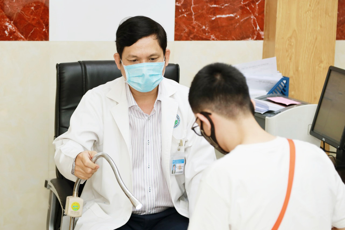 Bác sĩ Đoàn Văn Lợi Em khám, tư vấn bệnh cho một bệnh nhân nam tại Khoa Lâm sàng 3 Bệnh viện Da liễu TPHCM - ẢNH: L.A.