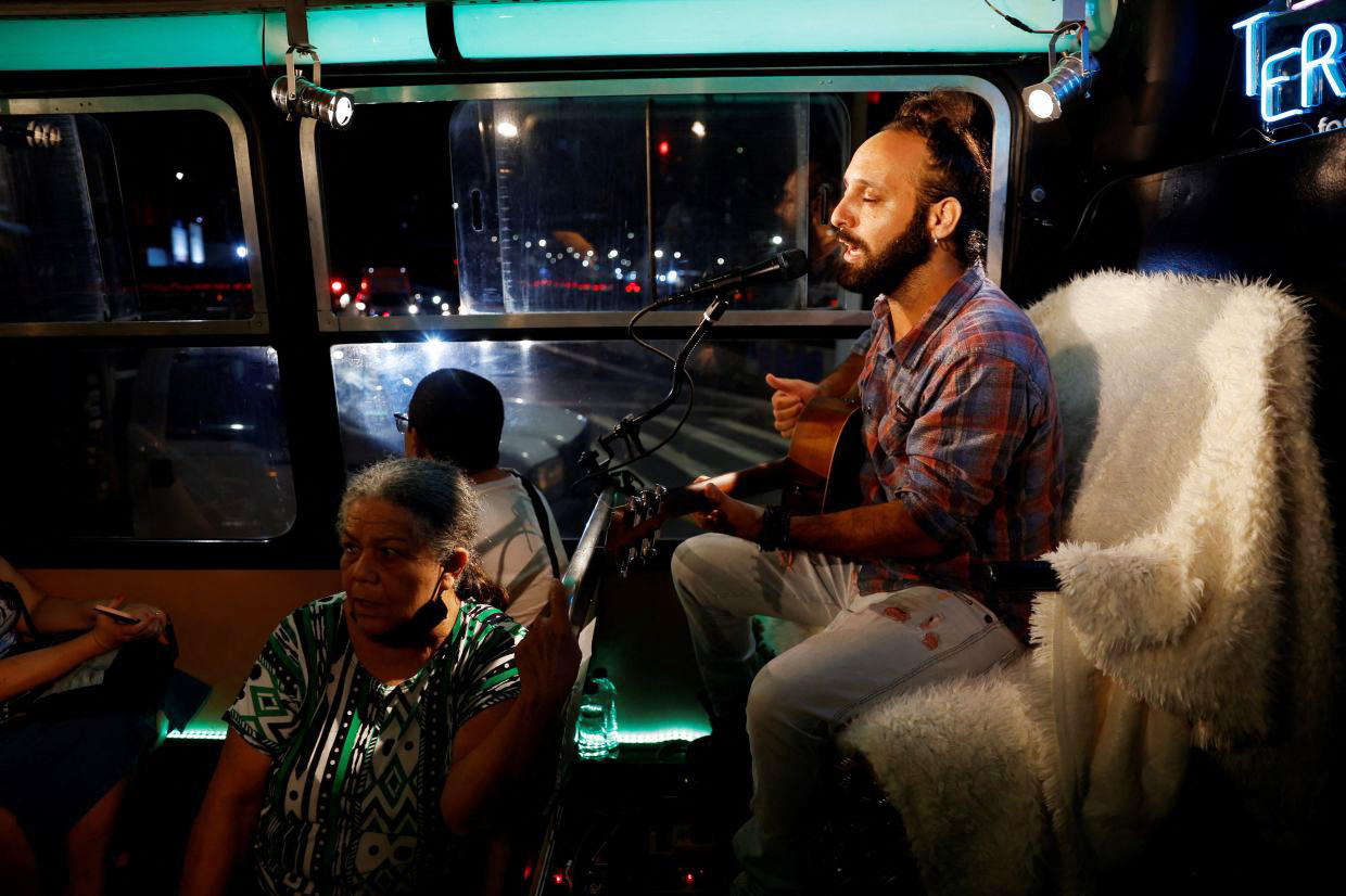 Nghệ sĩ Kaca Novais chơi nhạc trên một chuyến xe buýt văn hoá để phục vụ người dân