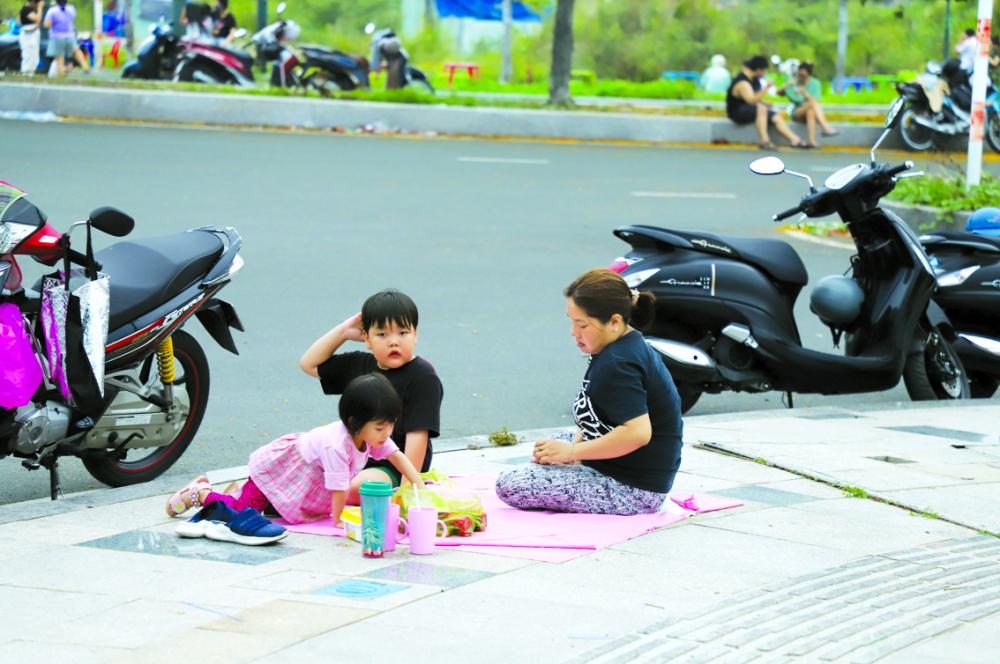 Nhiều gia đình trải bạt ngồi chơi ở các con đường trong khu đô thị mới Thủ Thiêm - ẢNH: THÀNH LÂM