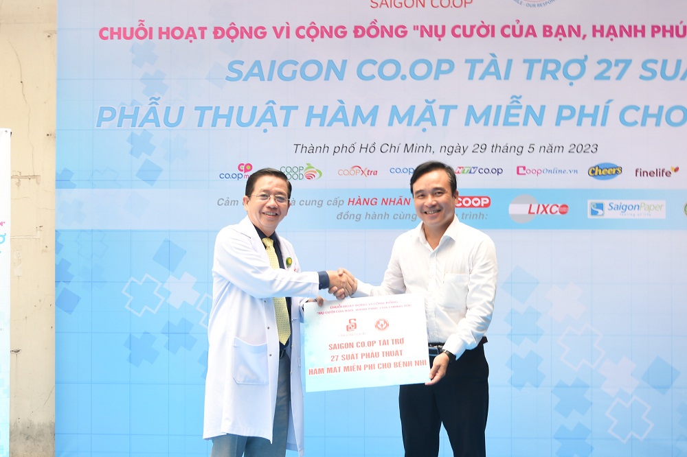 Ông Nguyễn Ngọc Thắng - Giám đốc khối vận hành hoạt động Co.opmart trao bảng tượng trưng tài trợ 27 suất phẫu thuật cho Bệnh viện Răng hàm mặt TPHCM - Ảnh: Saigon Co.op