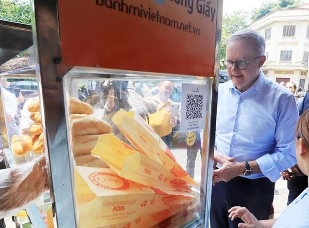 Thủ tướng Australia Anthony Albanese nghe giới thiệu về bánh mỳ patê của Việt Nam