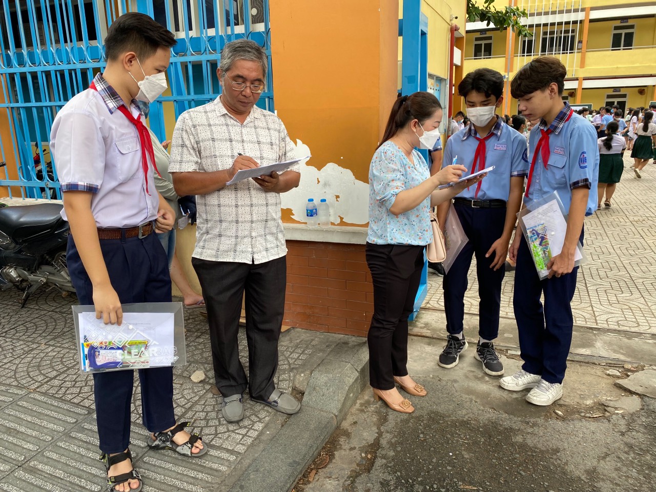 Cô Nguyễn Thị Quỳnh Trang cùng đồng nghiệp Trường THCS Nguyễn Văn Bé hỗ trợ điểm danh học sinh tại cổng điểm thi Trường THCS Trương Công Định