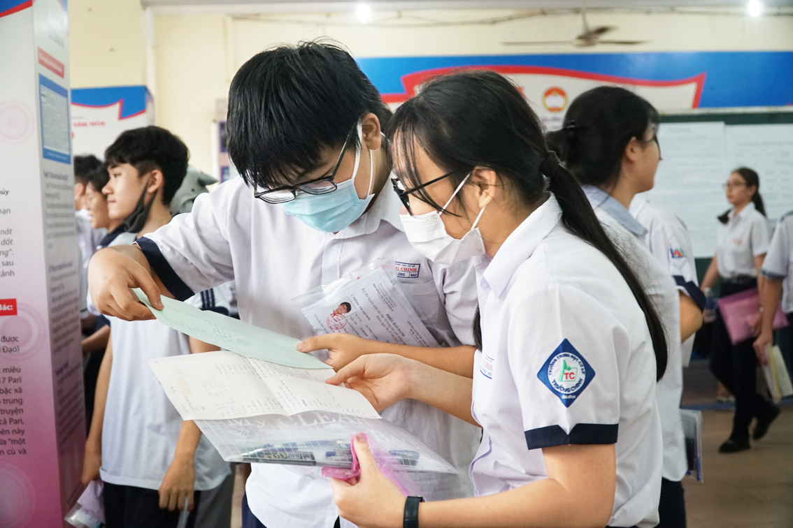 Thí sinh tại điểm thi Trường THPT Hùng Vương (quận 5) dò lại kết quả sau khi kết thúc môn thi tiếng Anh - Ảnh: Tam Nguyên