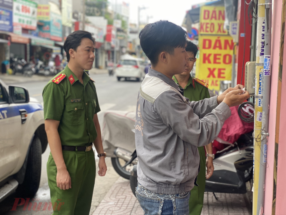 Công an đưa các đối tượng ra trụ điện, tường, nhà dân tháo gỡ các quảng cáo được chính các đối tượng dán