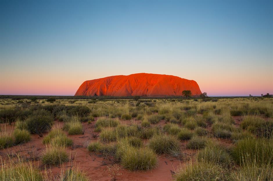Uluru, Úc Uluru hay Ayers Rock, trong Công viên Quốc gia Uluru-Kata Tjuta ở Lãnh thổ phía Bắc của Úc, đã mê hoặc mọi người trong nhiều thế kỷ và là một địa điểm linh thiêng đối với người Anangu, với giả thuyết cho rằng nó được hình thành bởi những sinh vật tổ tiên đã định hình thế giới. Khoa học cho thấy khối đá sa thạch bắt đầu hình thành cách đây khoảng 550 triệu năm, qua hàng thế kỷ xói mòn và uốn nếp đã tạo nên hình dạng hình bầu dục đặc biệt của nó. Bề mặt màu đỏ của nó là do quá trình oxy hóa, trong khi đá “tươi” bên dưới có màu xám.