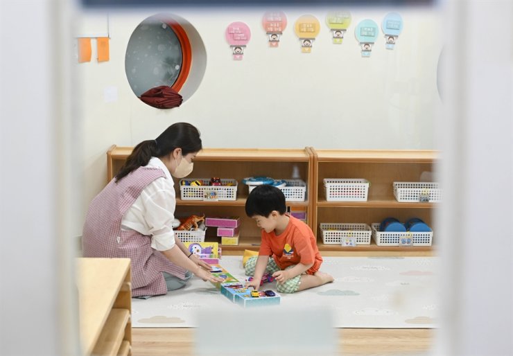 Một giáo viên và một cậu bé chơi tại một trung tâm chăm sóc ban ngày ở quận Songpa của Seoul vào Chủ nhật. Korea Times ảnh của Wang Tae-seok