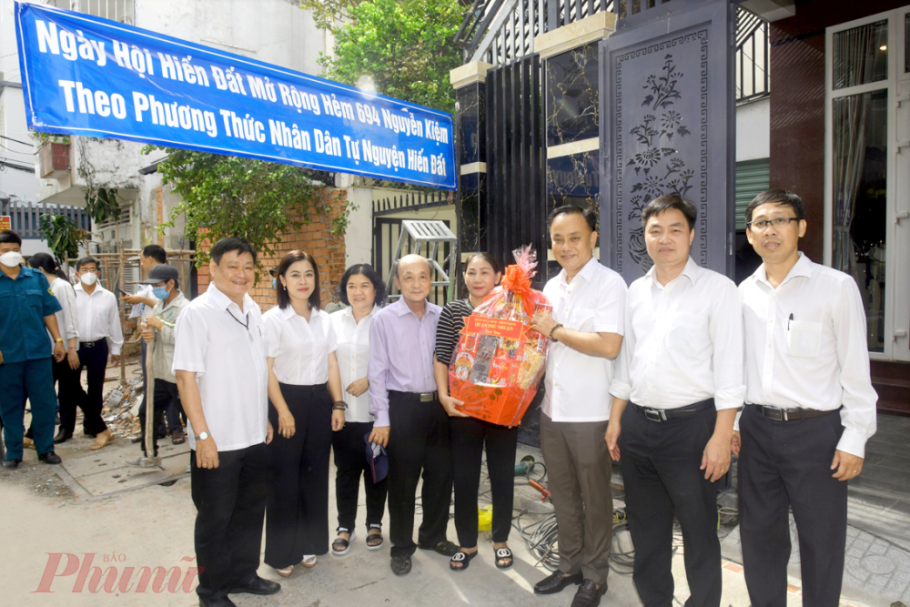 Bà Lê Thị Minh Thương nhận quà của UBND quận Phú Nhuận trong ngày hội hiến đất mở hẻm 694 Nguyễn Kiệm