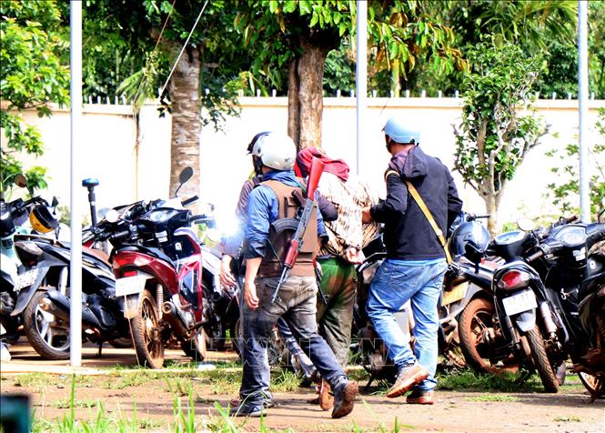 Công an dẫn giải các đối tượng nghi can trong vụ dùng súng tấn công trụ sở UBND 2 xã ở Đắk Lắk. Ảnh: Hưng Thịnh/TTXVN