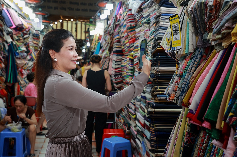 Một khách hàng đang thanh toán không dùng tiền mặt khi mua hàng hoá tại chợ Bến Thành. 