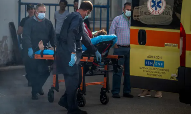 Nhân viên y tế với một người sống sót tại cảng ở Kalamata. Ảnh: Angelos Tzortzinis/AFP/Getty Images