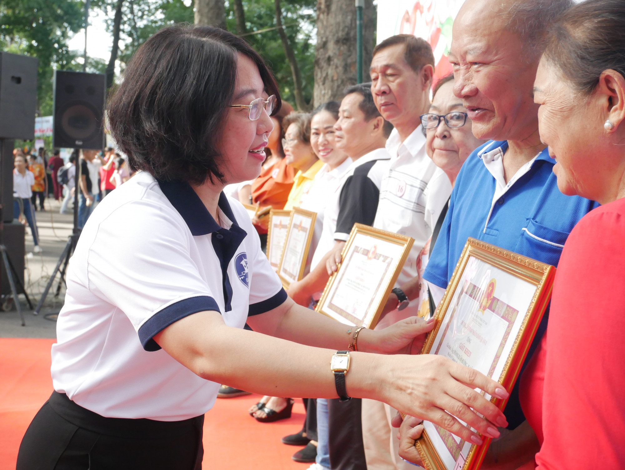 Bà Mai Thị Hồng Hoa - Phó chủ tịch UBND quận 1 tặng bằng khen cho các gia đình được quận vinh danh là gia đình hạnh phúc nhân dịp 28/6