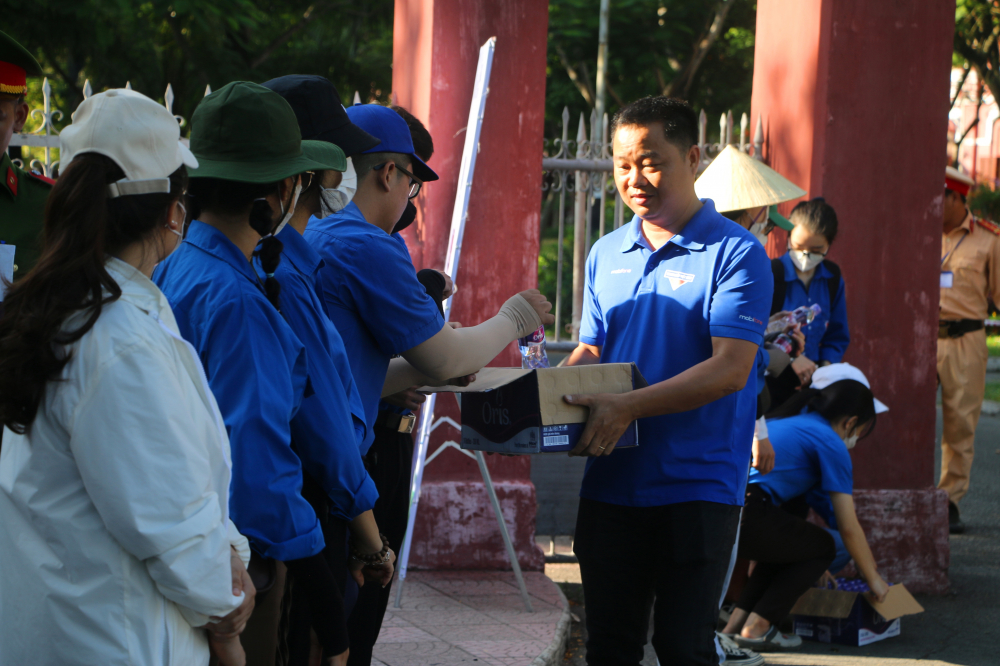 Người dân tặng quà cho lực lượng thanh niên tình nguyện giúp đỡ thí sinh trước cổng trường