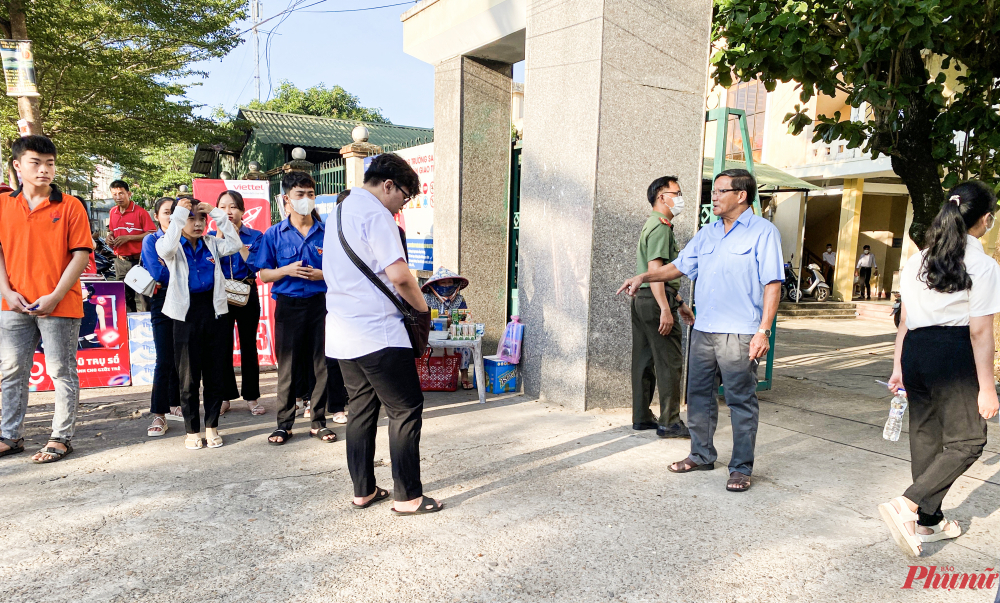 Lực lượng chức năng nhắc nhở thí sinh không mang túi xách vào điểm thi