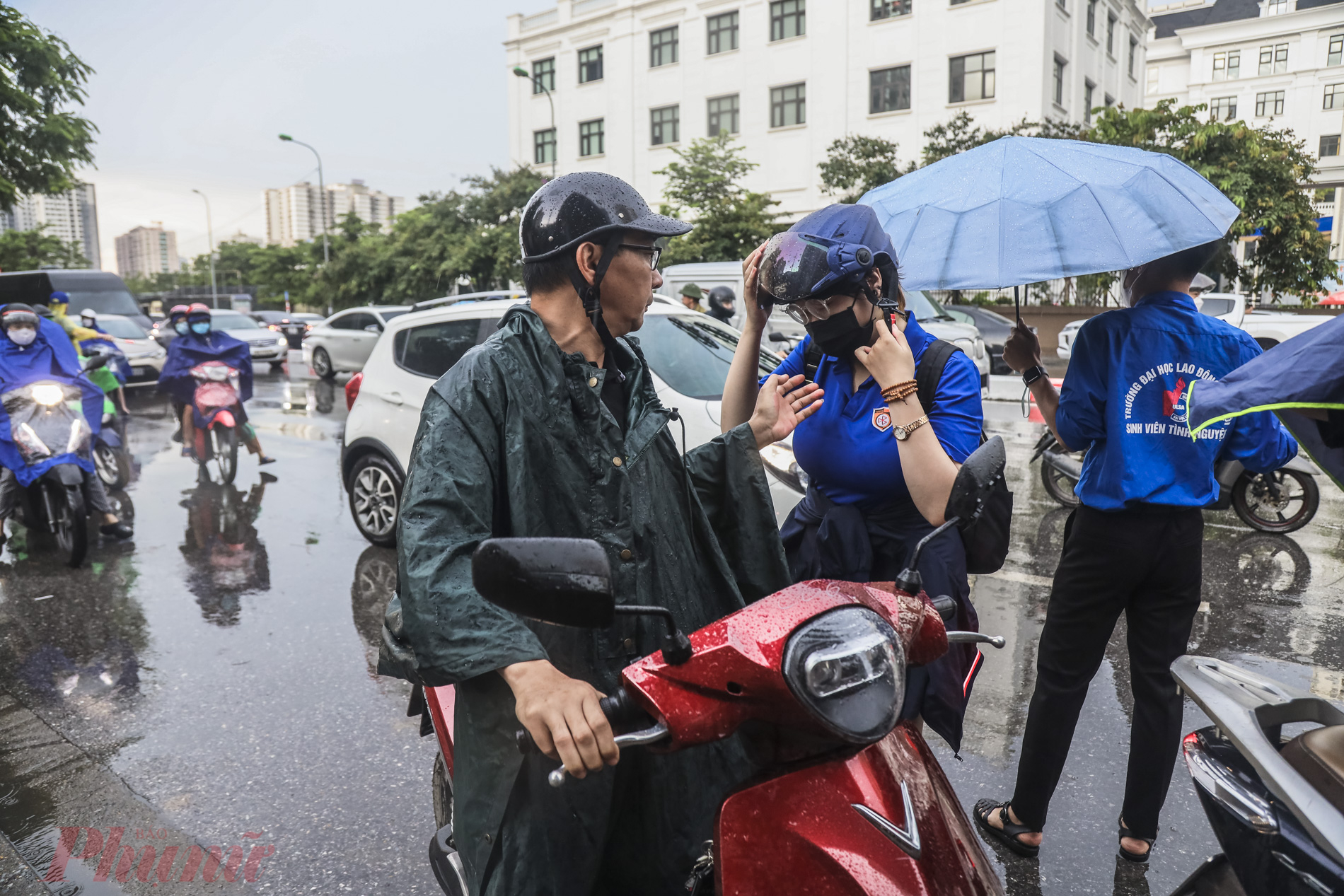 Phụ huynh bồn chồn đội mưa ngóng theo con vào điểm thi.