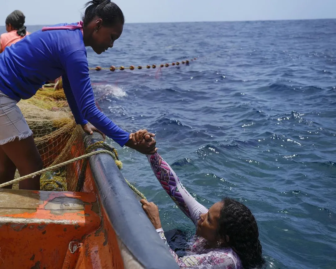 Phụ nữ Venezuela giúp đỡ nhau khi làm việc ngoài biển.