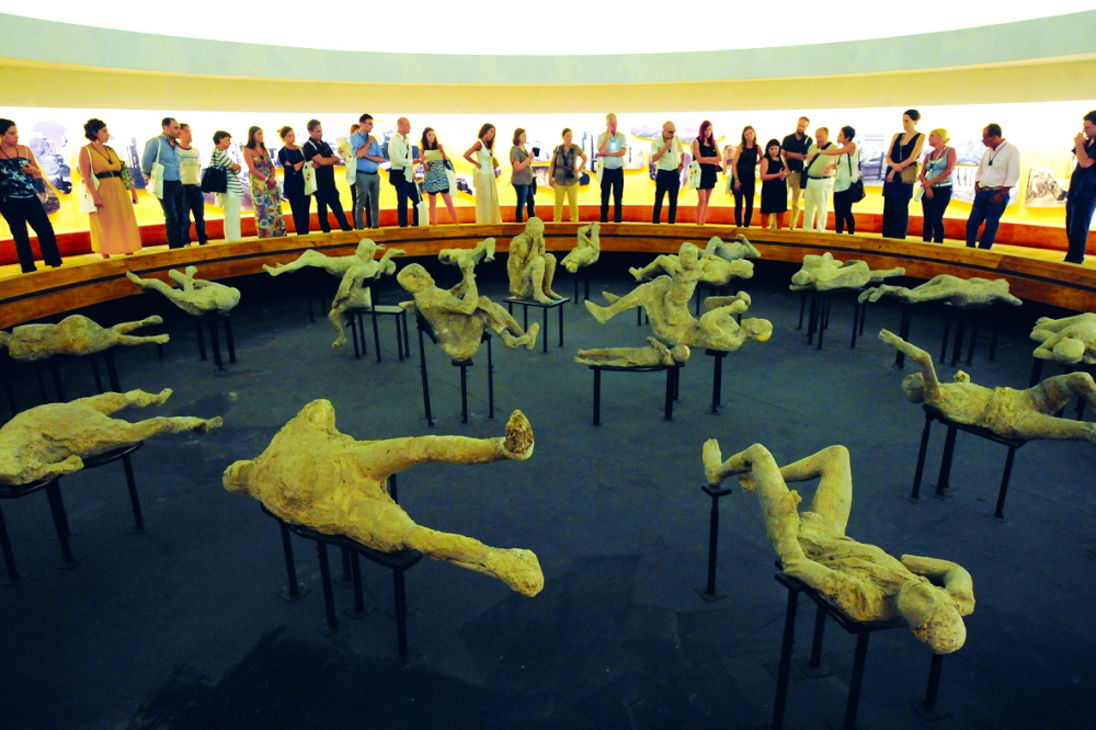 Du khách quan sát di hài người cổ đại thiệt mạng trong vụ phun trào núi lửa đã nhấn chìm thành cổ Pompeii (La Mã) năm 79 sau Công nguyên - ẢNH: GETTY