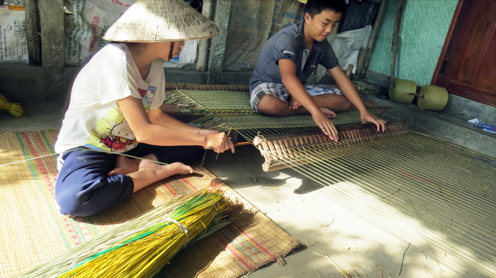 Những đứa trẻ ở thôn Phú Tân 1 học làm chiếu để giữ nghề truyền thống và phụ giúp gia đình