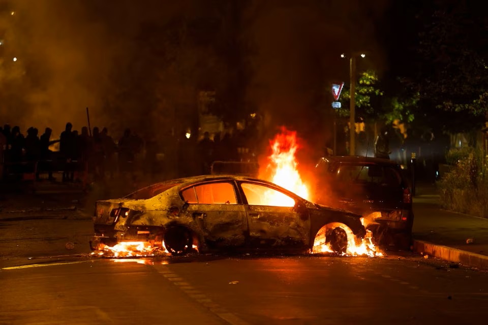 Một chiếc xe bị đốt cháy trong cuộc đụng độ giữa người biểu tình và cảnh sát