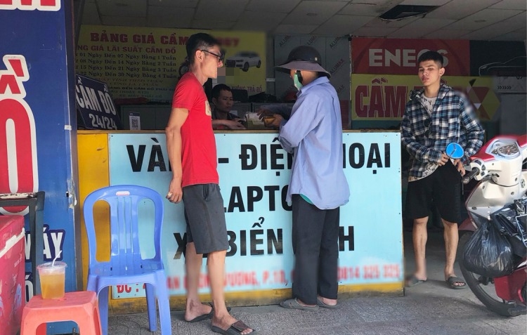 Một khách hàng đến cầm cố xe máy cho một tiệm cầm đồ trên đường An Dương Vương, quận Bình Tân