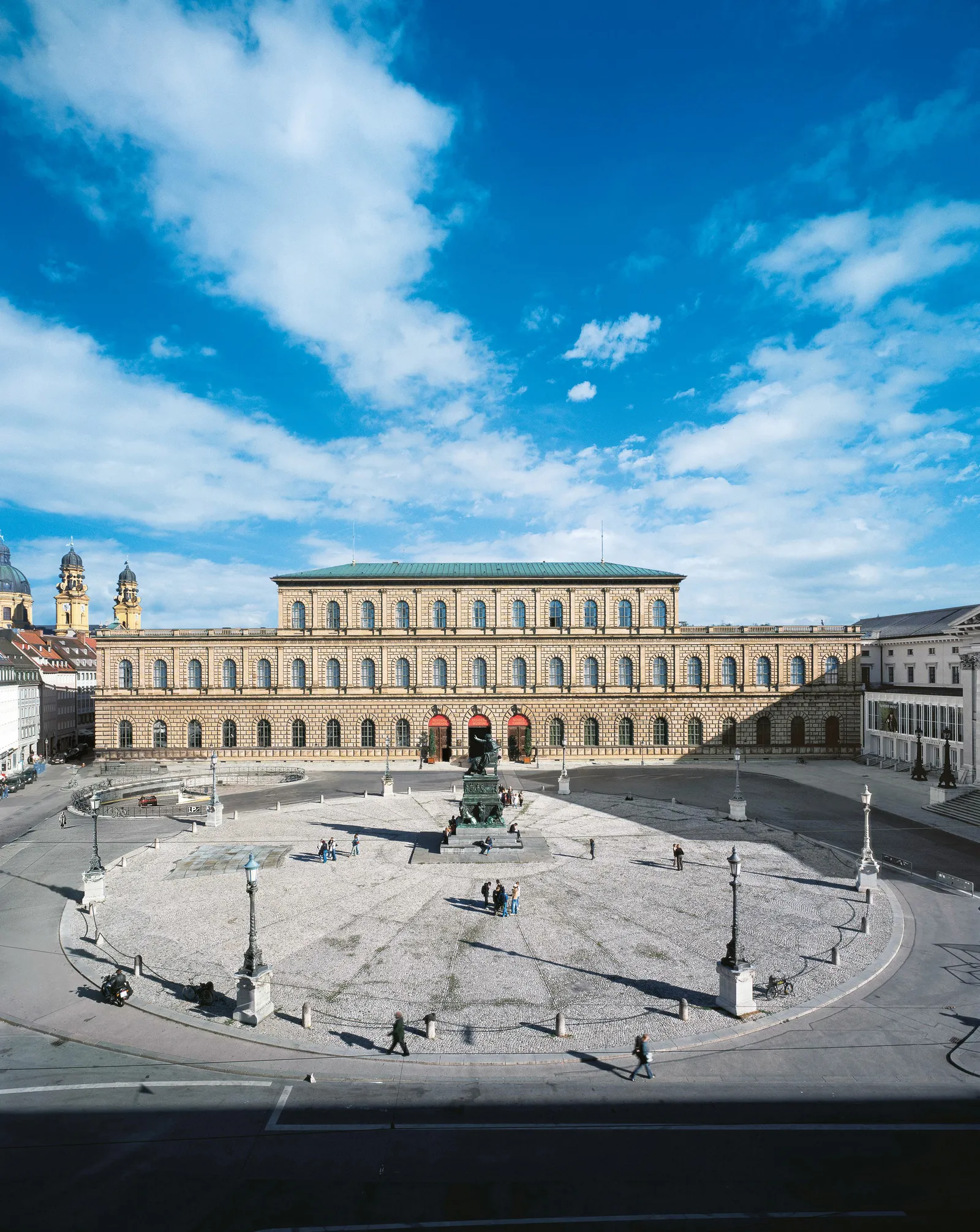 Những phần sớm nhất của cung điện hoàng gia tại vị trí của Residenz ở Munich có từ những năm 1300, và qua nhiều thế kỷ, các cánh, sân trong và các công trình bổ sung mới đã được xây dựng bởi nhiều vị vua khác nhau. Königsbau, hay Tòa nhà của Vua, có niên đại từ thời Vua Ludwig I, người trị vì từ năm 1825 đến năm 1848. Có một chút bí ẩn xung quanh lý do tại sao nó lại giống cung điện Medici đến vậy. Ludwig I đã ra lệnh rõ ràng cho kiến ​​trúc sư triều đình của ông, Leo von Klenze, xây dựng mô hình tòa nhà dựa trên cung điện trước đó ở Florence. Klenze cũng sử dụng Palazzo Rucellai, nằm ở Florence, như một mô hình khác.