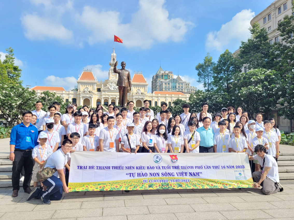 Các trại sinh kiều bào và tuổi trẻ thành phố chụp ảnh lưu niệm trước tượng đài Bác Hồ tại phố đi bộ Nguyễn Huệ