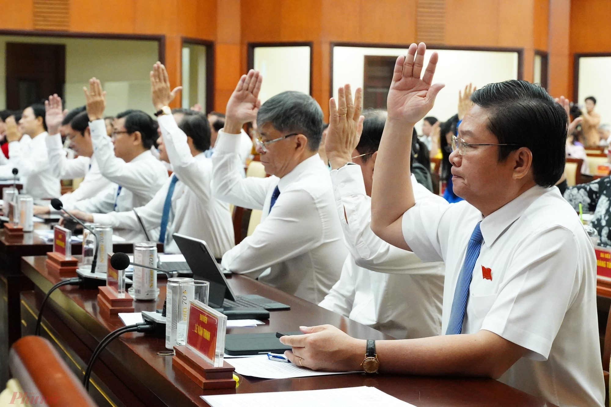 Các đại biểu HĐND TPHCM giơ tay biểu quyết