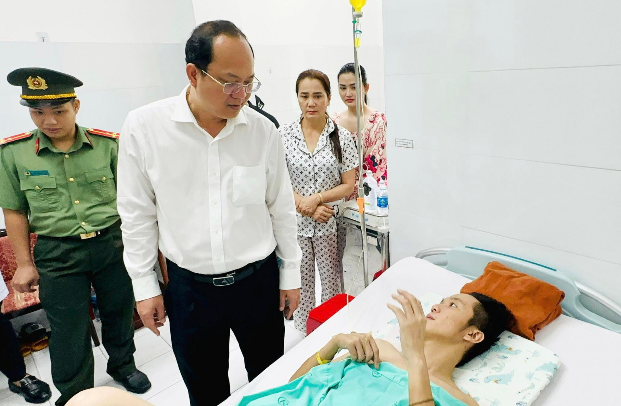 Phó bí thư TPHCM Nguyễn Hồ Hải (áo trắng) hỏi thăm tình hình sức khoẻ, động viên Thượng uý Đàm Đình Bốp - Ảnh: Dương Trang