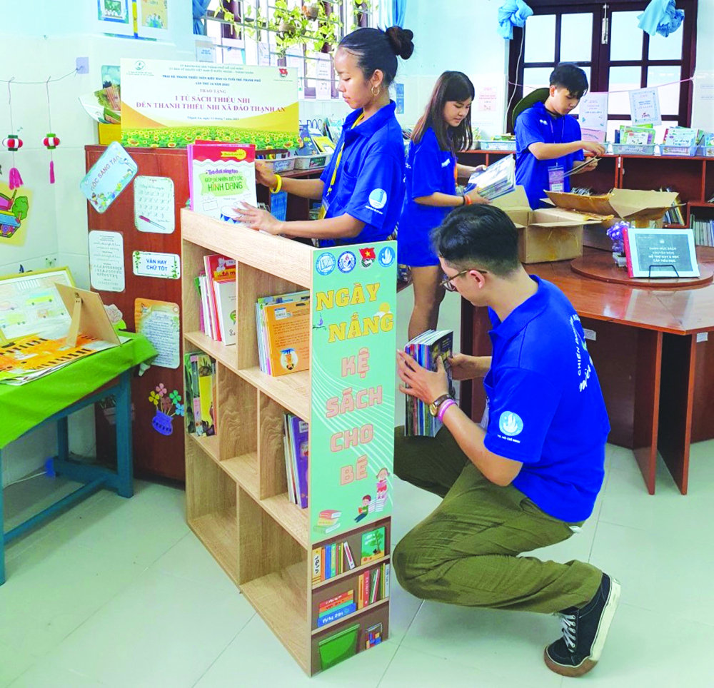 Các trại sinh đang lắp đặt kệ sách thư viện cho thiếu nhi xã đảo Thạnh An, huyện Cần Giờ - ẢNH: THU LÊ