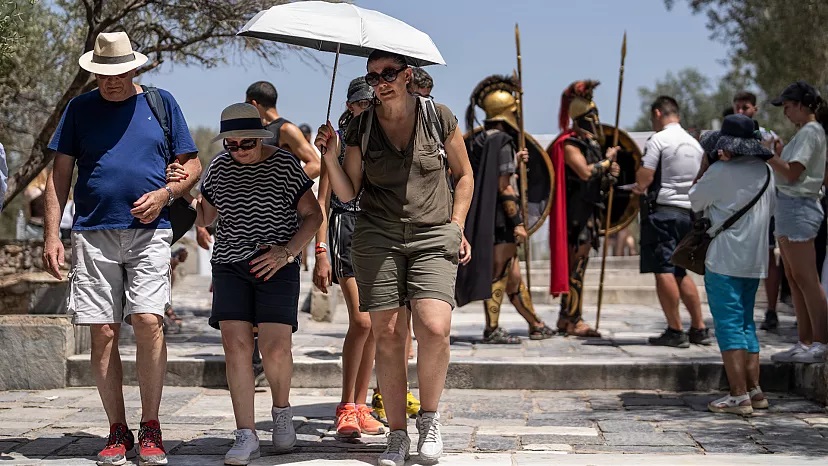 Khách du lịch rời khỏi Thành cổ Acropolis của Athens khi Bộ Văn hóa Hy Lạp đóng cửa di tích hầu hếy thời gian ban ngày vì nắng nóng. (Ảnh: AP)