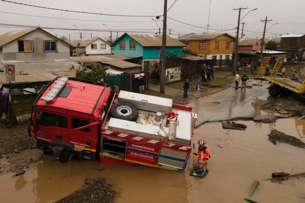 Xe cứu hỏa mắc kẹt trong hố do lũ lụt ở Coltauco, Chile, ngày 25/6. Hàng nghìn người Chile bị cô lập hoặc mất nhà cửa do mưa xối xả. (Ảnh: Anadolu Agency/Getty Images)