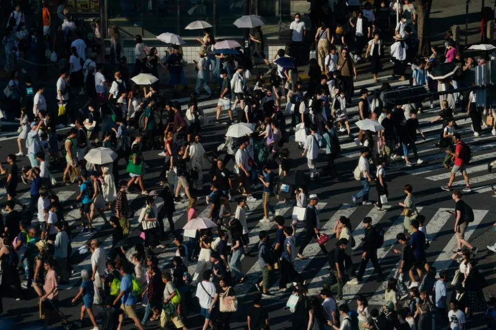  Người dân mang theo dù để che nắng tại một giao lộ tại Tokyo, Nhật Bản vào ngày 17/7. (Ảnh: Kiichiro Sato/AP)