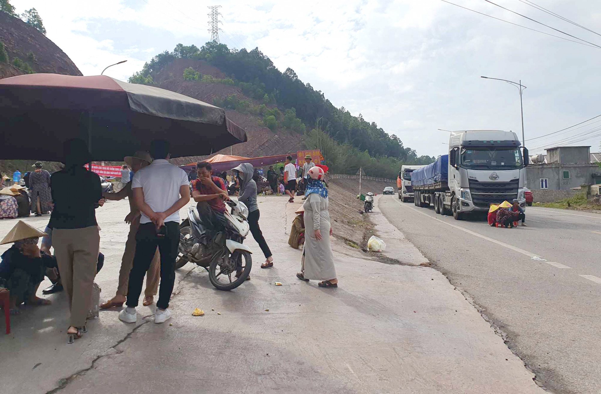 Nhiều người dân mang theo băng rôn, tập trung chặn xe tải chở hàng vào cảng Vissai - Ảnh: Khánh Trung