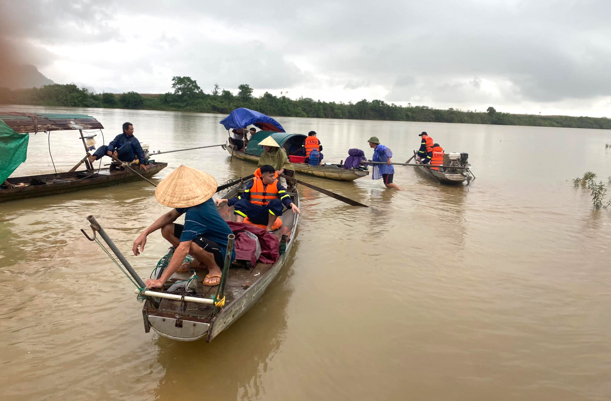 Lực lượng chức năng cùng người dân dùng thuyền tìm kiếm các học sinh gặp nạn trên sông Lam - Ảnh: Khánh Trung